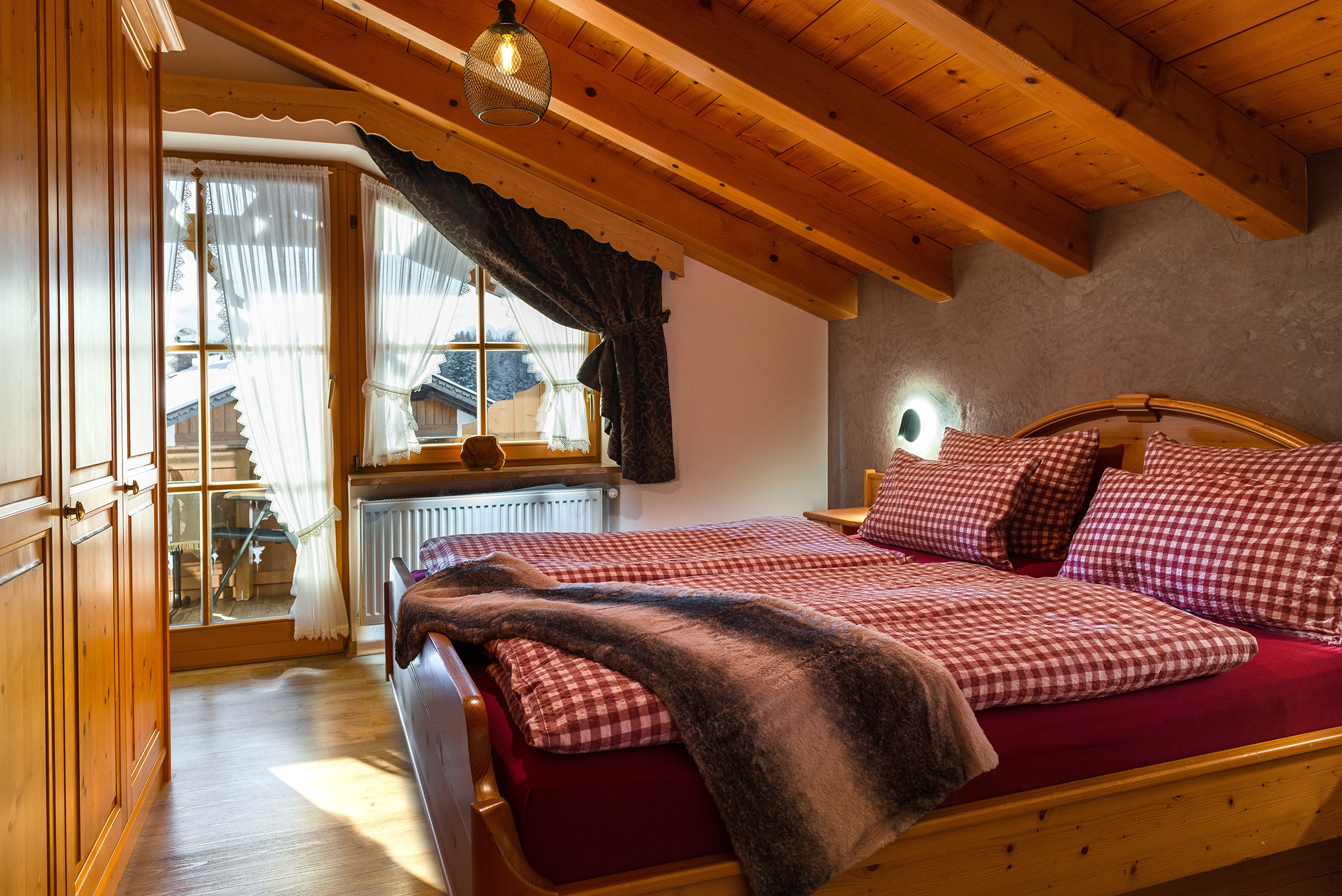 Gemütliches Schlafzimmer mit karierter Bettwäsche_Alpenparadies_Krün